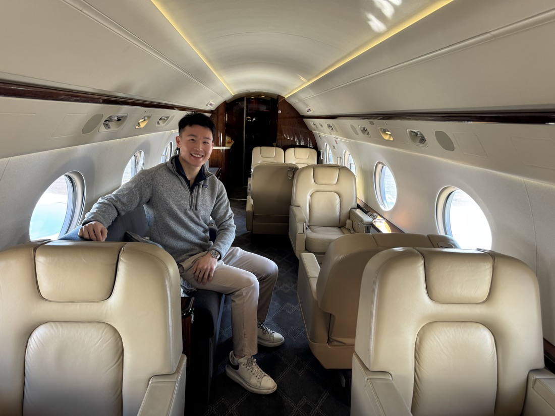 Justin Zhou seated in the cabin of a private jet
