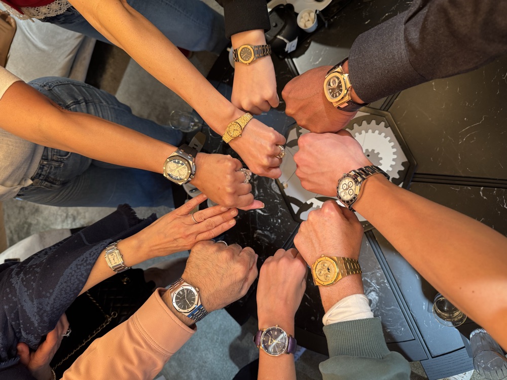 A circle of collectors comparing watches on the wrist