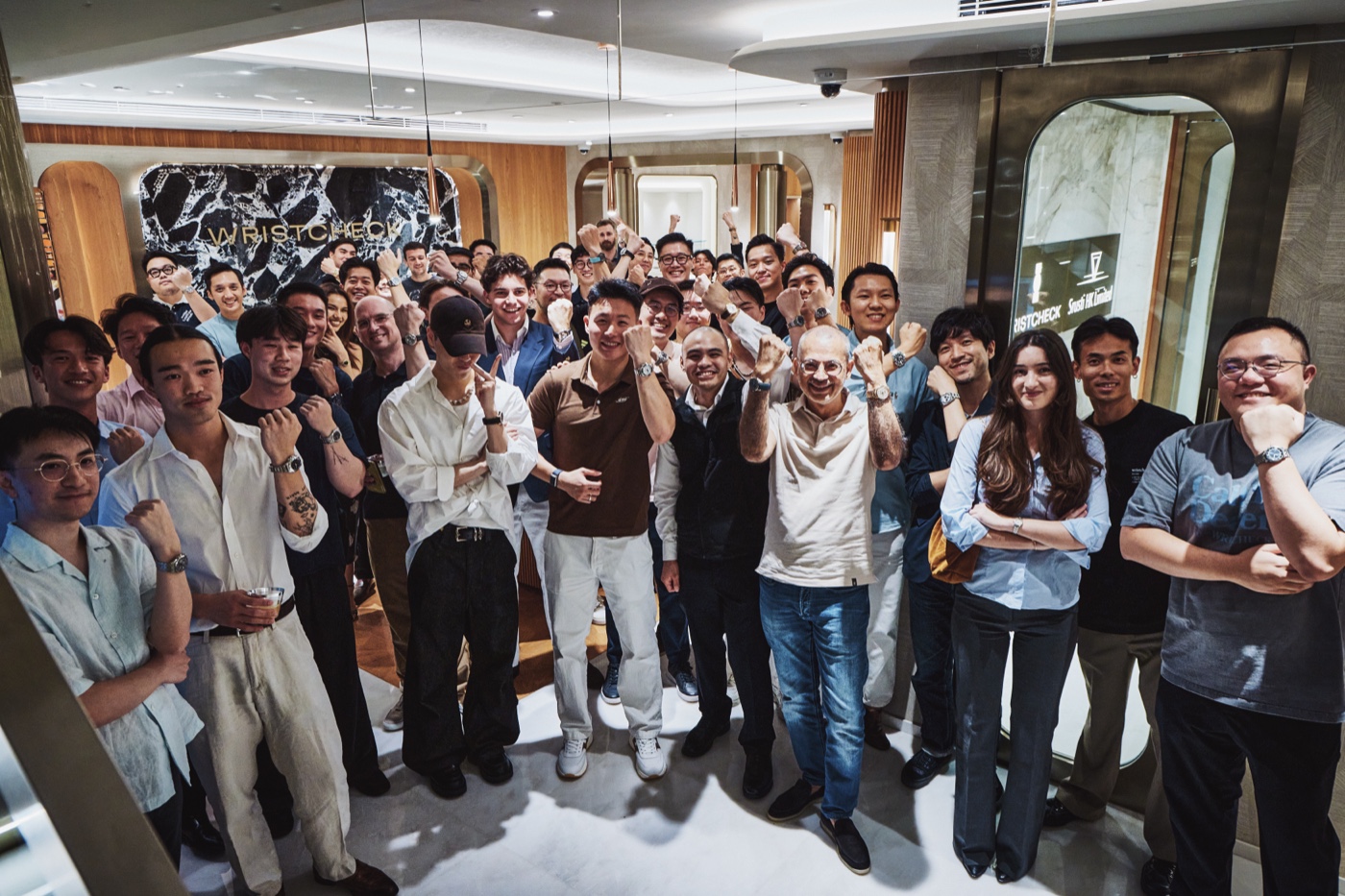 A large group of JZO Club members raising their watches together at a Wristcheck meet-up